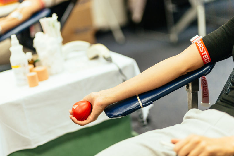 Attēls ar cilvēka roku asins ziedošanas procesa laikā